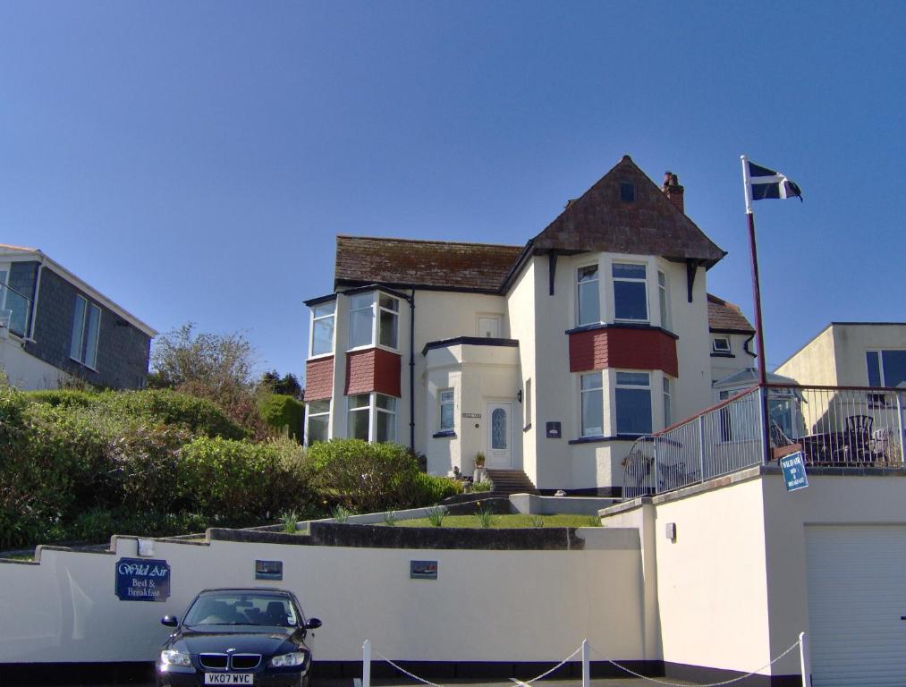 a car parked in front of a white house at Wild Air Guest House in Mevagissey