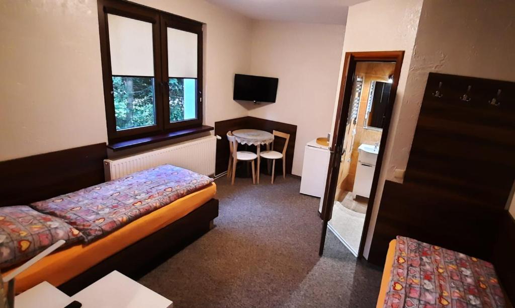 a room with two beds and a desk and a table at Noclegi in Ruda Śląska