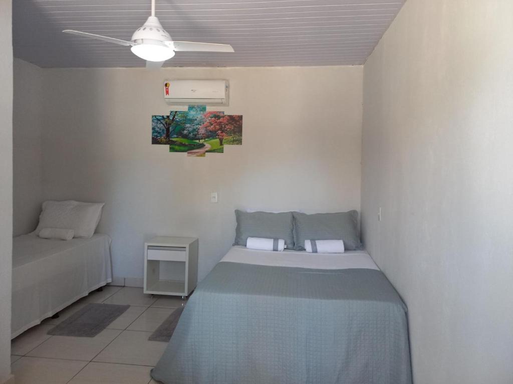 a small bedroom with a bed and a night stand at HELLO MT POUSADA in Nobres