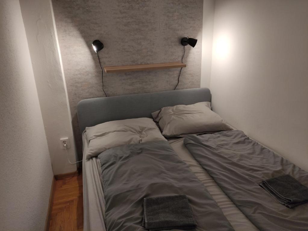 Cama pequeña en habitación pequeña con lámpara en Bristol Apartments 2, en Baja