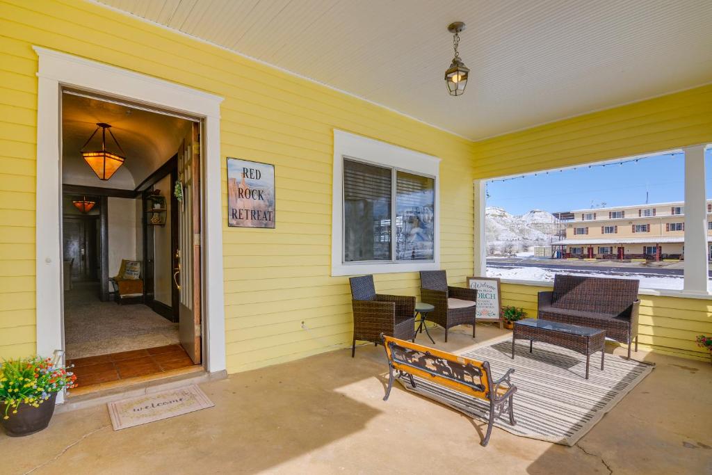 Casa amarilla con porche con bancos y mesas en Beautiful Historic Home Near Bryce Canyon!, en Cannonville