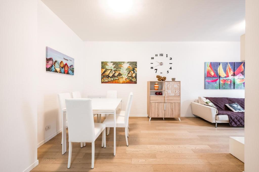 a white dining room with a table and chairs at La Casa di Edo - WiFi Parking free in Modena