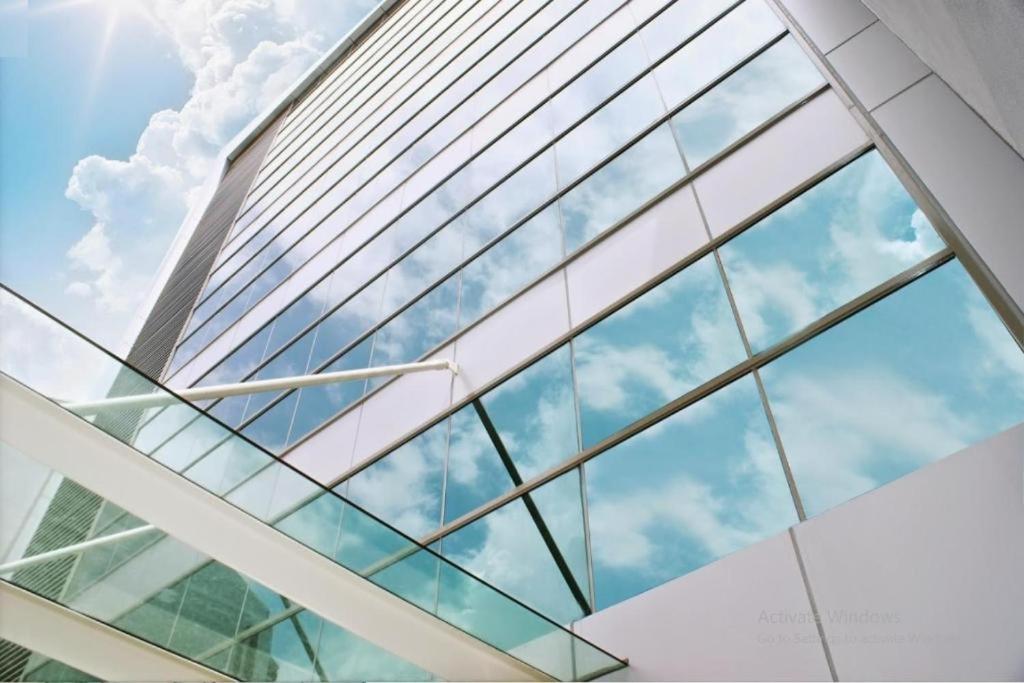 uma fachada de vidro de um edifício com o céu ao fundo em Xpeed Holiday Hotel em Kuala Lumpur
