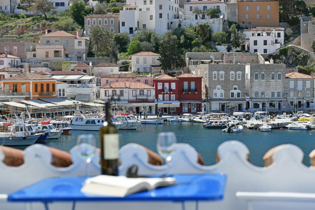 una botella de vino sentada en una mesa en un puerto en Delfini Hotel en Hydra