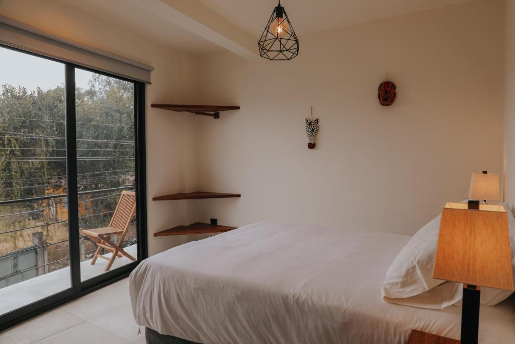 1 dormitorio con cama y ventana grande en Lahos Apartament's, en Panajachel