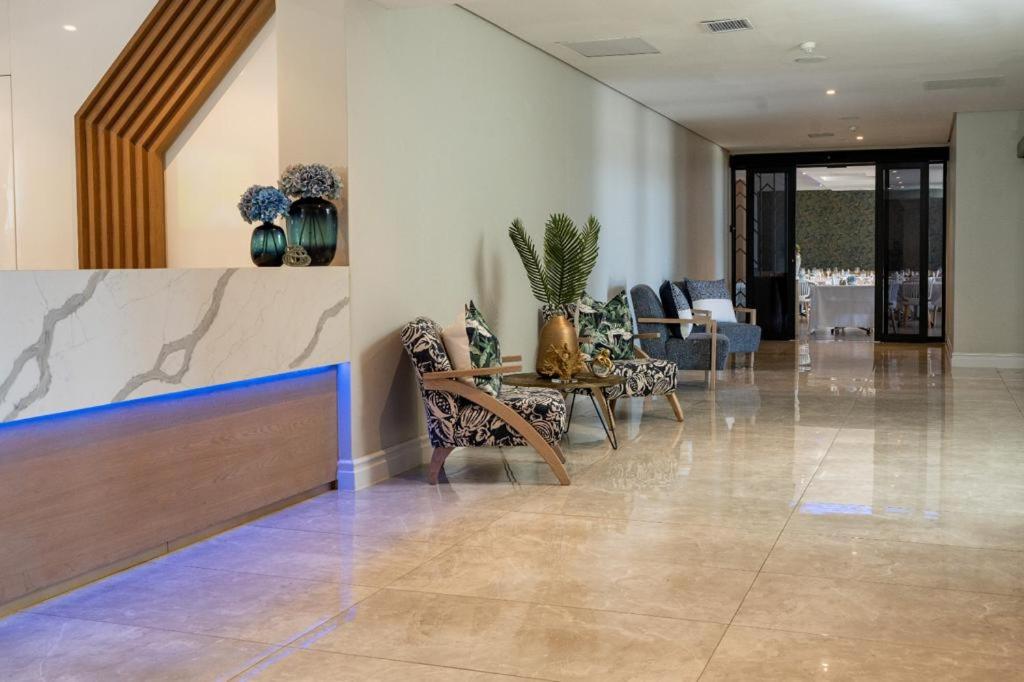 12 Oceans Hotel and Conference Centre في Kingsborough: لوبي وكراسي وطاولة في مبنى