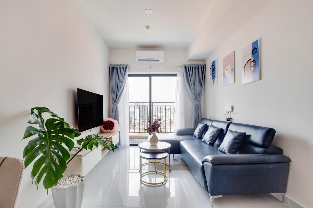 a living room with a blue couch and a window at SMILE HOME - SOHO COMFORTABLE - BEST LOCATION district 1 in Ho Chi Minh City