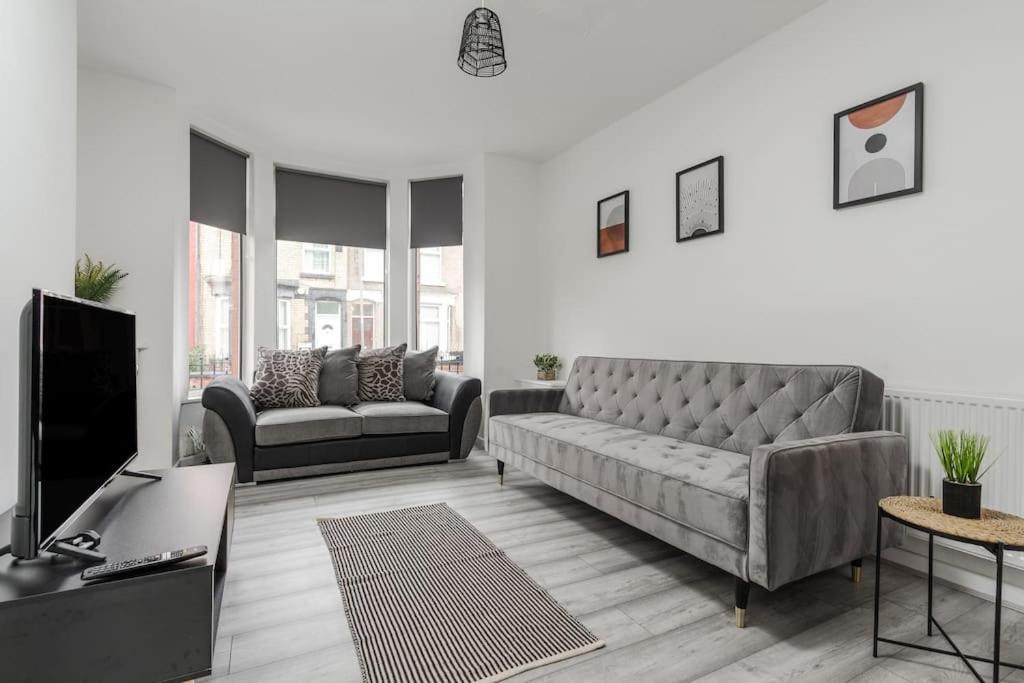 a living room with a couch and a tv at Liverpool 3 bed house (free parking) in Liverpool