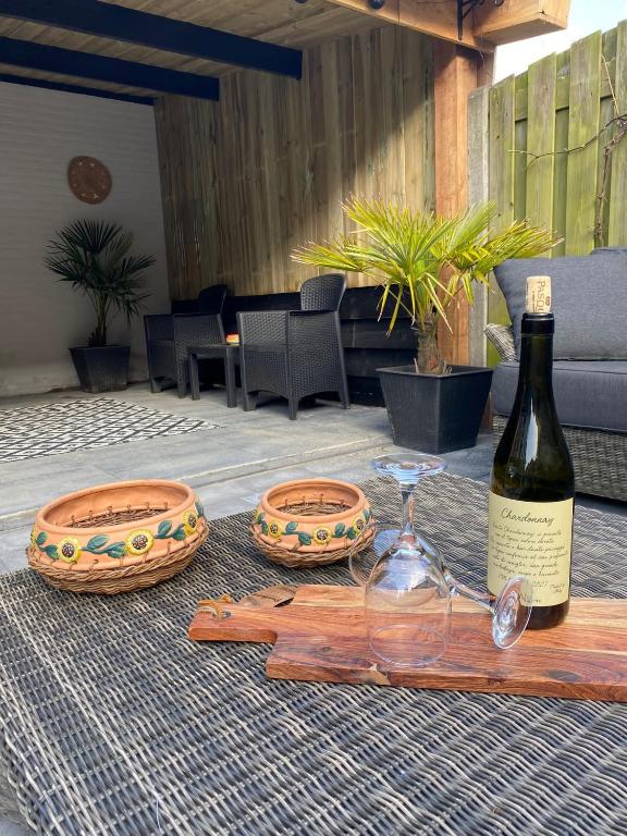 a bottle of wine and glasses on a table at huisje in zeeland helemaal gerenoveerd in Sint Annaland