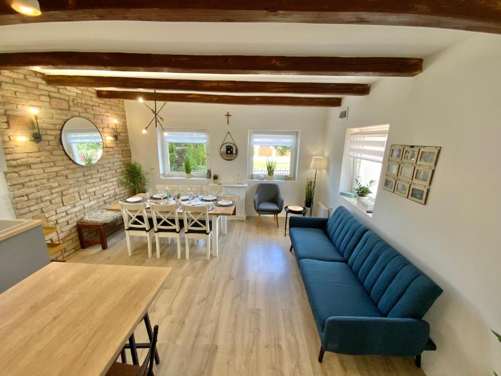 un salon avec un canapé bleu et une salle à manger dans l'établissement IstEni apartman Zamárdi, akár 12 fő! Balaton, à Zamárdi