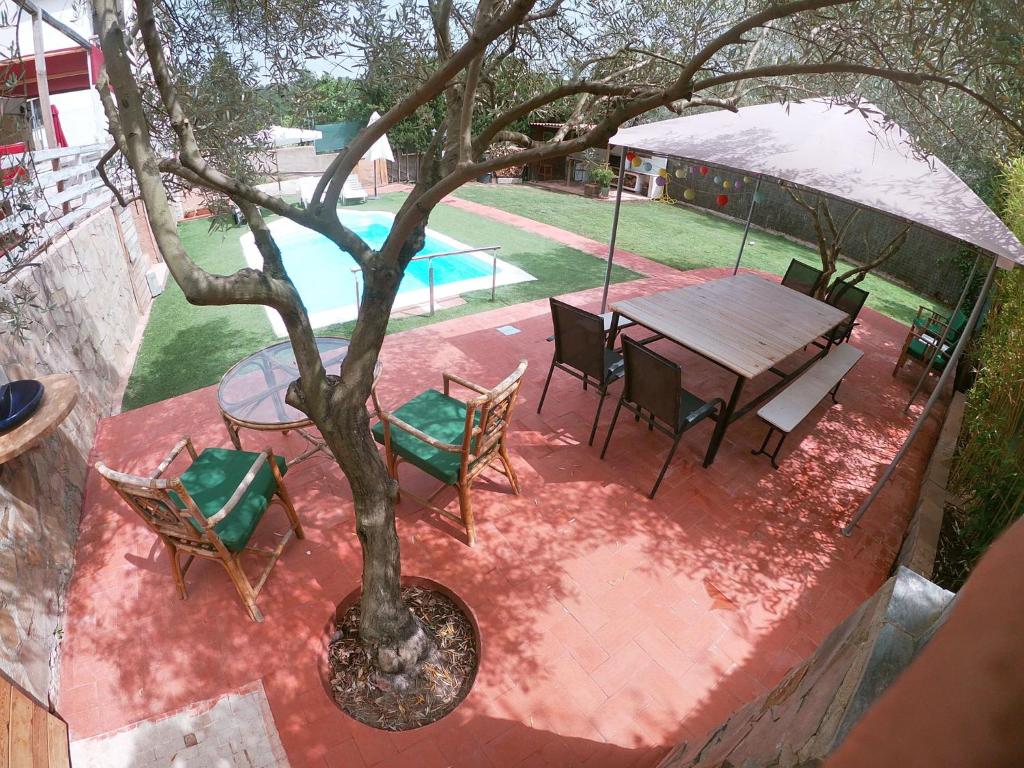 a patio with a table and chairs and a tree at HappyHouse Pura vida in Mont Barbat
