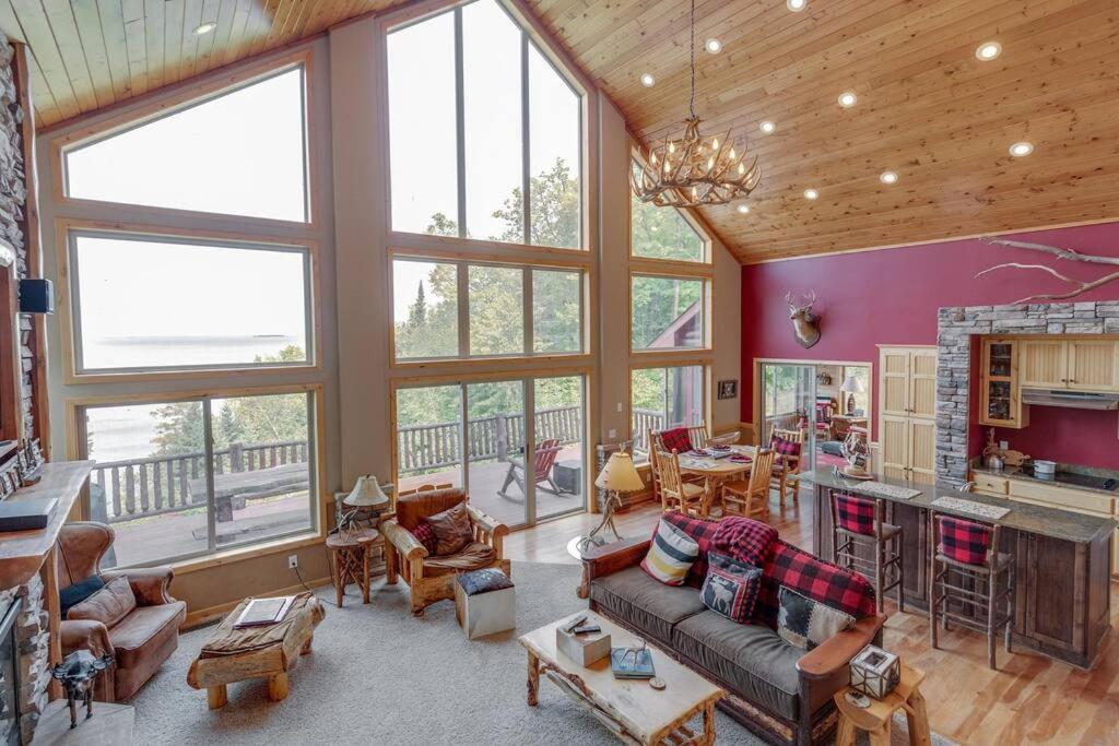 ein großes Wohnzimmer mit großen Fenstern und einer Küche in der Unterkunft Luxury Leech Lake Home 15 Minutes to Walker in Walker