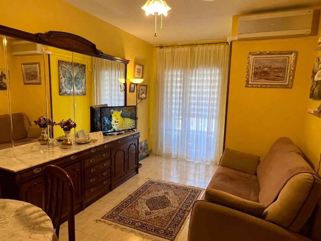 un soggiorno con pareti gialle, divano e TV di Apartament Montana a Torrevieja