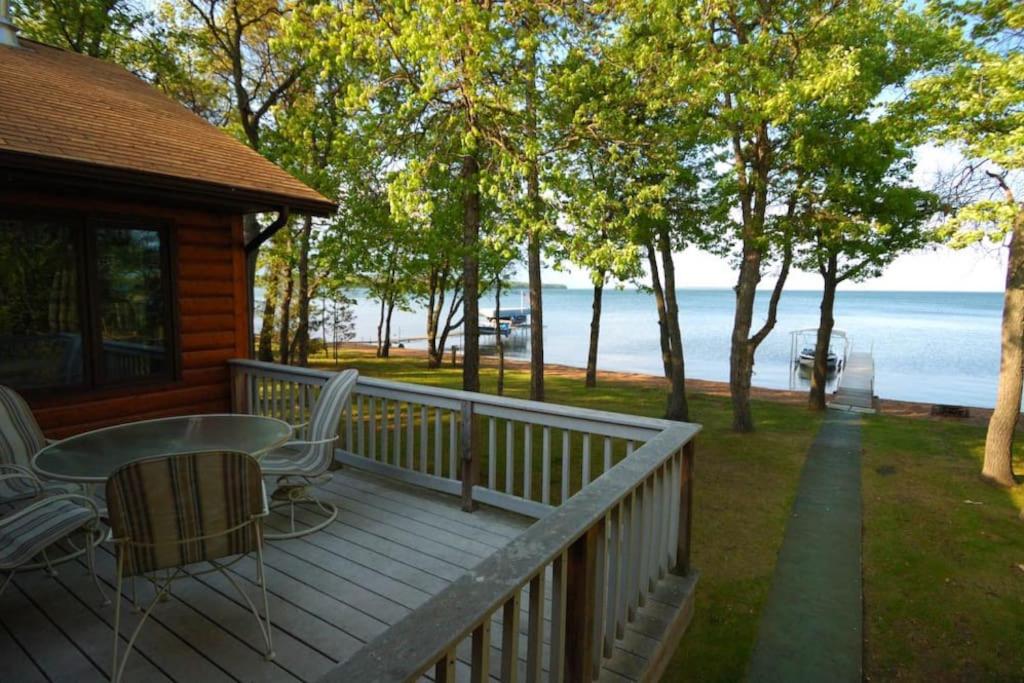 a porch of a cabin with a table and chairs at Dog Friendly Leech Lake Home w Perfect Beach Garage Boat Lift in Walker