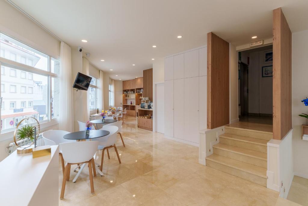 a kitchen and dining room with a table and chairs at Hotel Panadeiramar in Sanxenxo