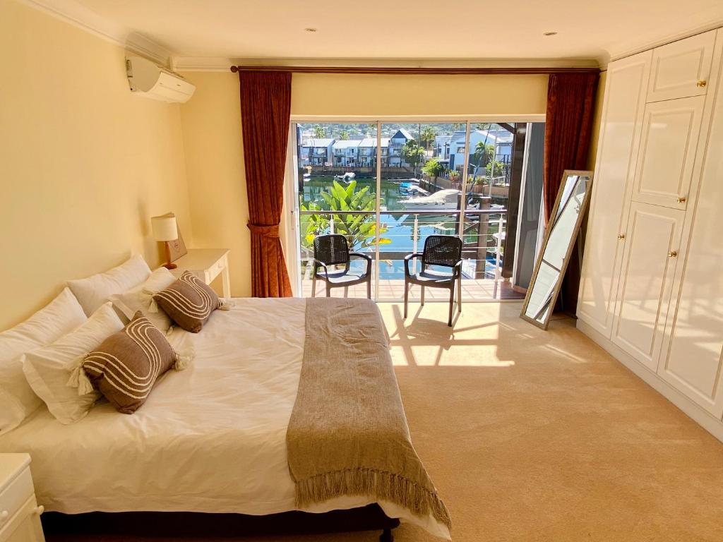 a bedroom with a large bed and a balcony at 42 Spinnaker, The Quays in Knysna