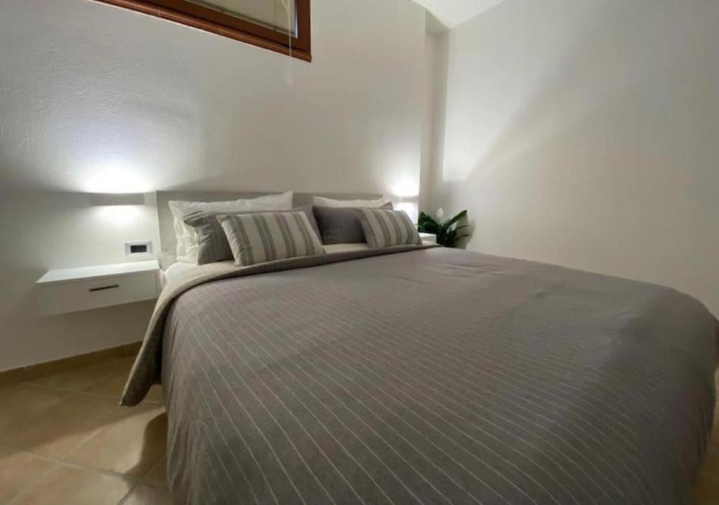 a bedroom with a large bed with two pillows at [Loft Comodo ed Elegante] • Wi-Fi e Colazione in Sanluri