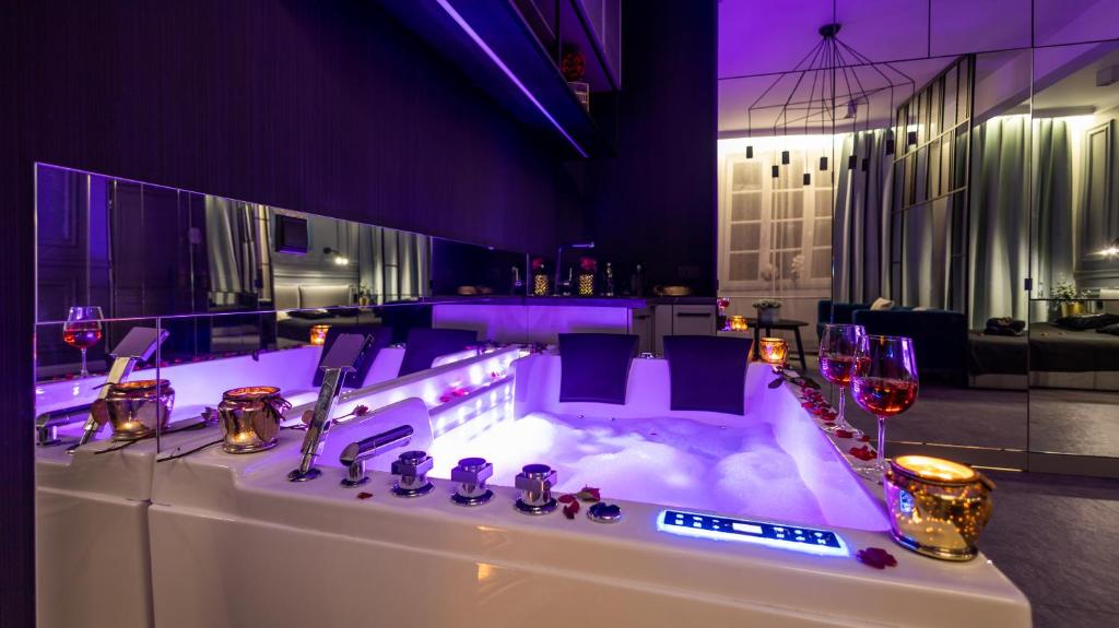 a bath tub in a room with purple lighting at Glamour Jacuzzi Apartment in Kraków