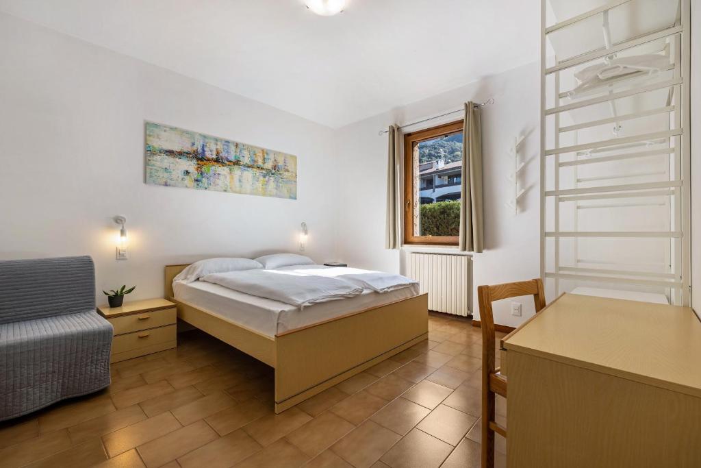 um quarto com uma cama, uma secretária e uma janela em Casa Milani Malcesine apt 4 em Malcesine