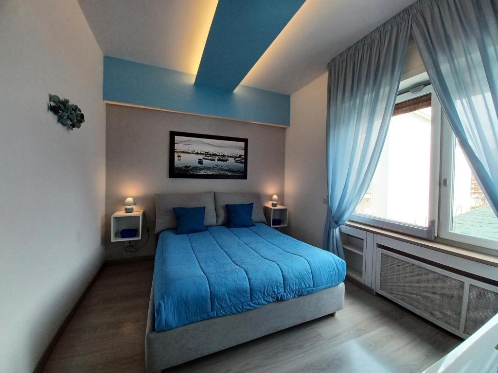 sypialnia z niebieskim łóżkiem i oknem w obiekcie Giulia BB Sorrento w Sorrento
