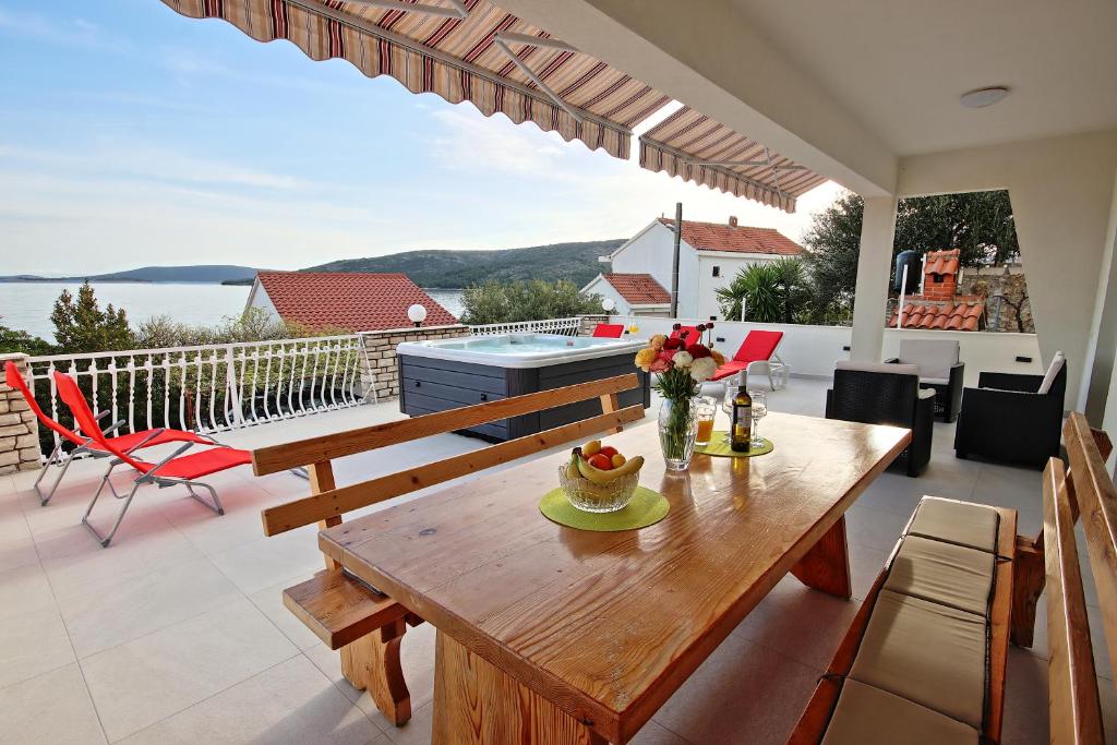 a dining room with a table and a balcony at Apartman Slavko in Seget Vranjica