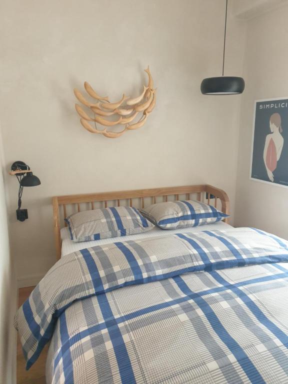 Schlafzimmer mit einem Bett mit blauer und weißer Bettwäsche in der Unterkunft Tiny studio 2 min walking distance from the port in Volos