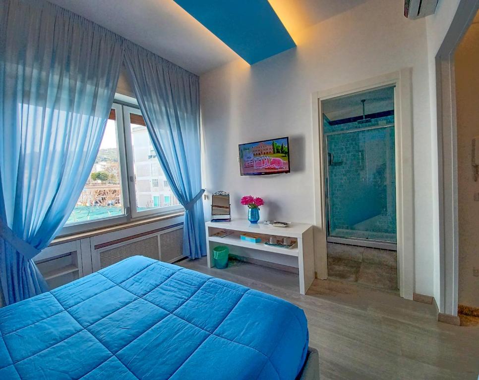 sypialnia z niebieskim łóżkiem i oknem w obiekcie Giulia BB Sorrento w Sorrento