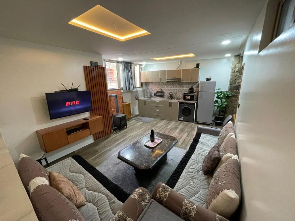 een woonkamer met een bank en een tv bij Harmony in Azrou