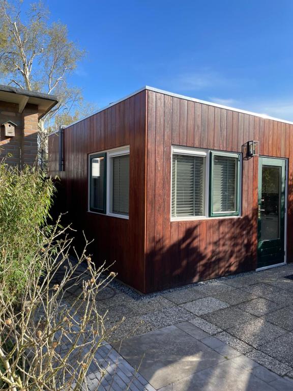 ein Holzhaus mit einer Tür und zwei Fenstern in der Unterkunft Bed & Breakfast Danina in Sassenheim