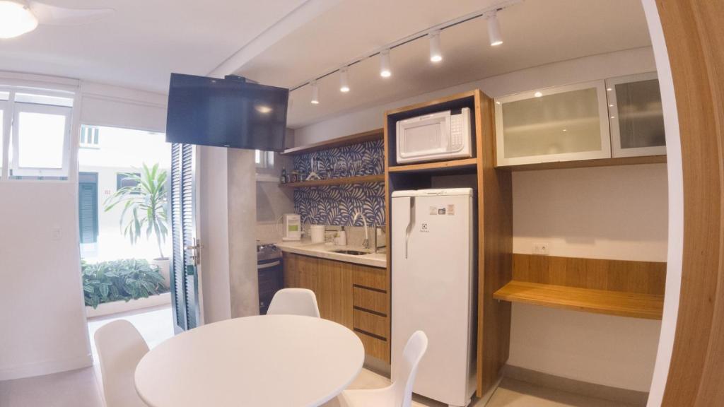 包波的住宿－Porto Paúba Flat 116，厨房配有桌子和白色冰箱。