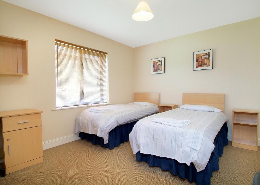 a bedroom with two beds and a window at Ballyraine Self Catering in Letterkenny