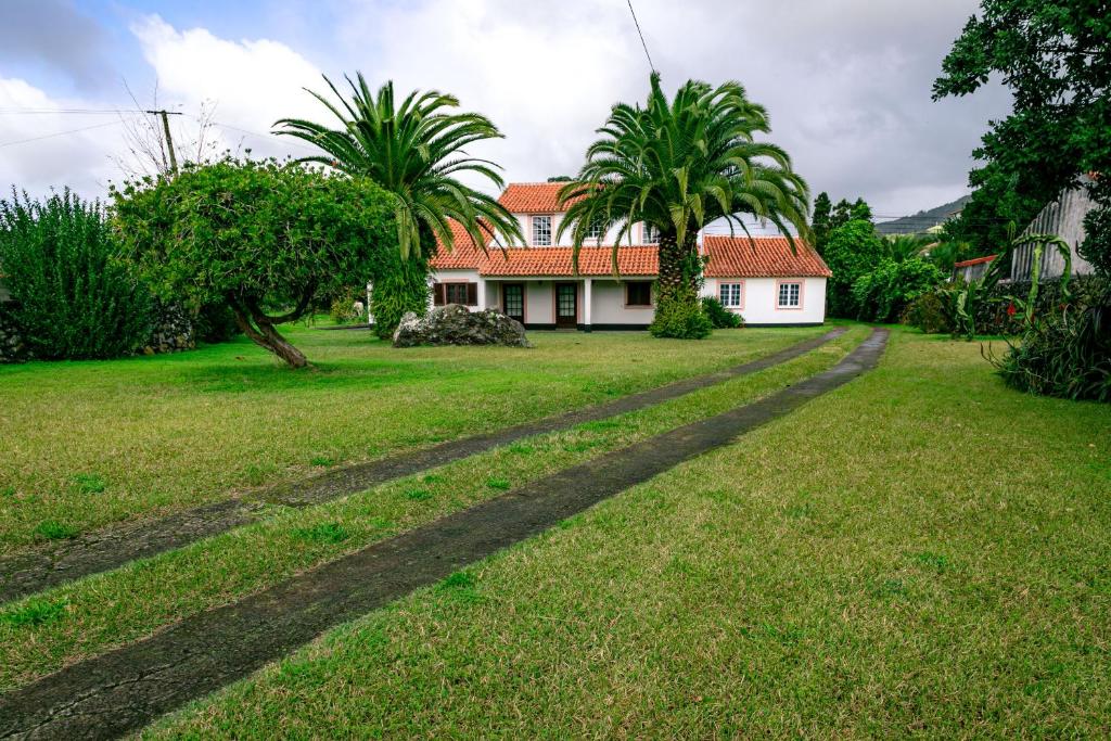 una casa con palme e una strada sterrata di Casa de Família ad Angra do Heroísmo