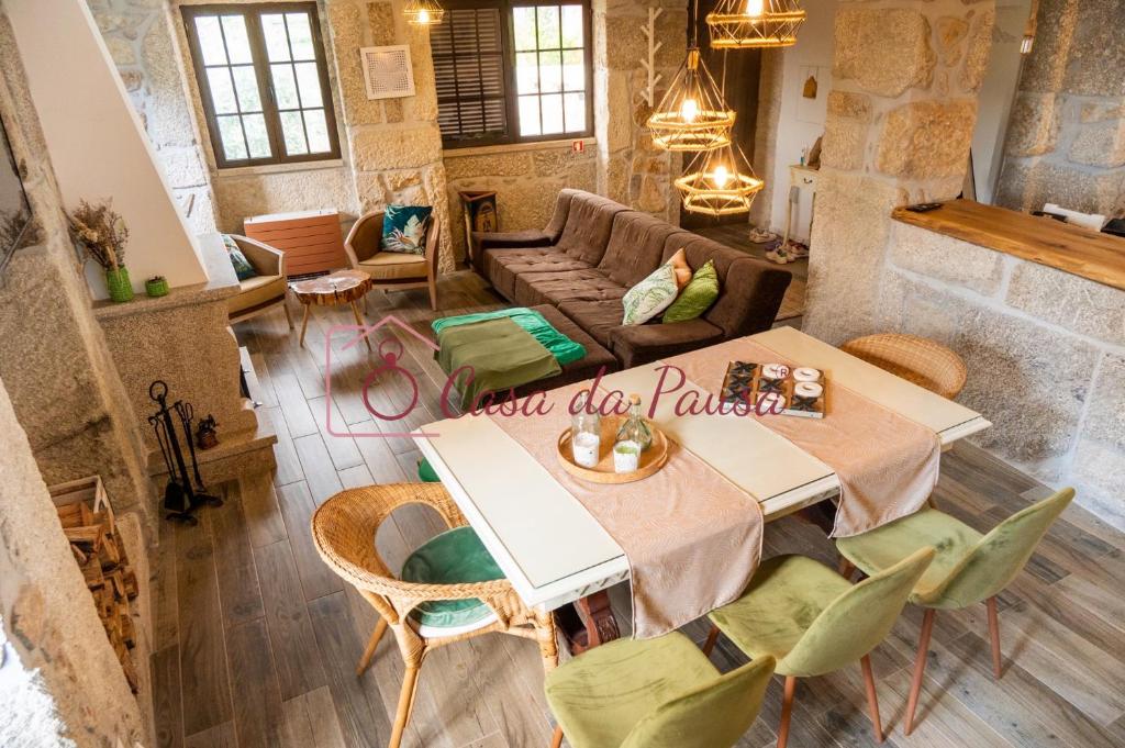 - un salon avec une table, des chaises et un canapé dans l'établissement Casa da Pausa, à Vila Verde