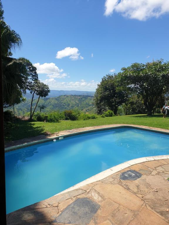 una piscina azul con vistas a las montañas en Sunset Manor en Bothaʼs Hill