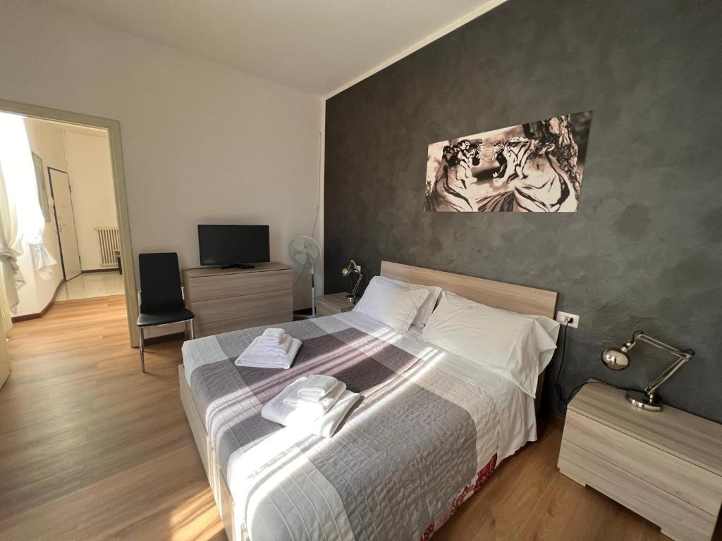 a bedroom with a large bed and a television at Ancient Courtyard Bonanomi in Como Historic Centre in Como