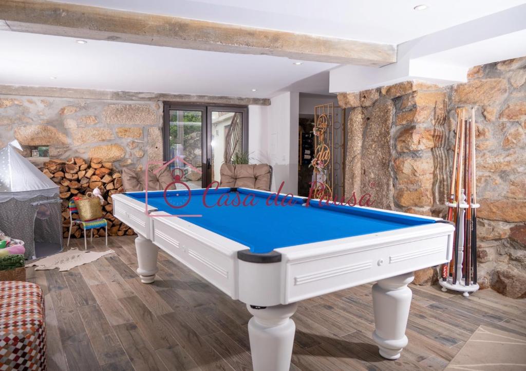 a pool table in a room with a stone wall at Casa da Pausa by TonsdeVerde in Vila Verde