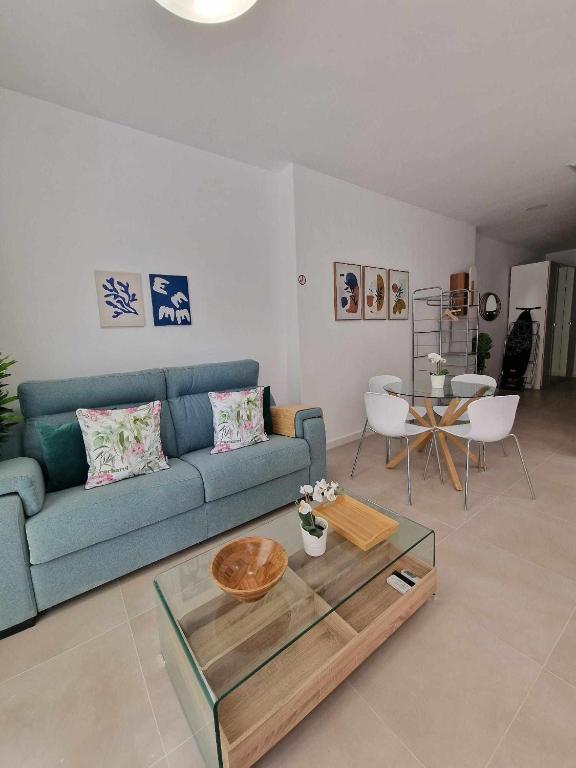 a living room with a blue couch and a table at Urban suite 1 in Málaga