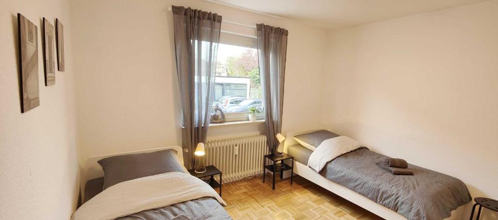 2 Betten in einem kleinen Zimmer mit Fenster in der Unterkunft Apartment in Hanau in Hanau am Main