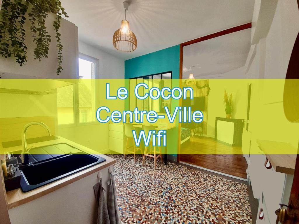 a yellow kitchen with a sink and a counter at Le Cocon in Rennes