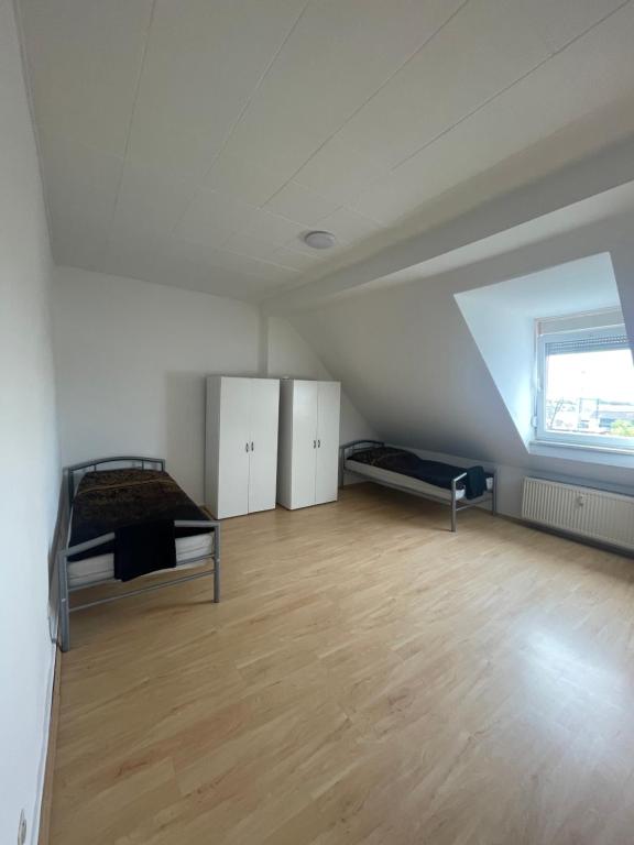 um quarto no sótão com uma cama e piso em madeira em 4 Zimmer Bruchsal City Monteurzimmer Küche/Bad em Bruchsal
