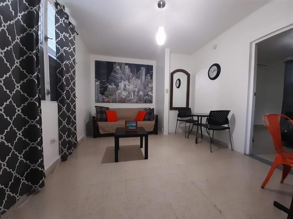 ein Wohnzimmer mit einem Sofa und einem Tisch in der Unterkunft Cozy Apartment across the San Juan Airport in San Juan