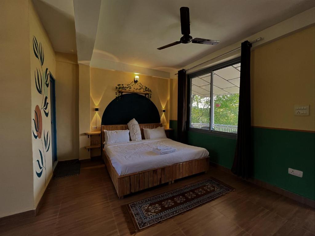 a bedroom with a large bed and a window at THG - The Hidden Garden Bir in Bīr