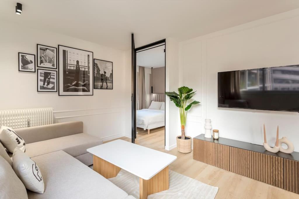 un salon avec un canapé et une télévision dans l'établissement Luxurious 3 min walk from Eiffel Tower, à Paris