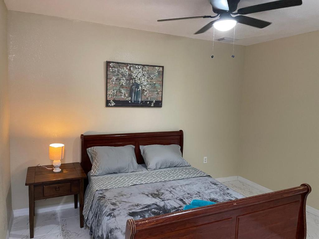 um quarto com uma cama e uma ventoinha de tecto em Terrace Guest House em Tampa