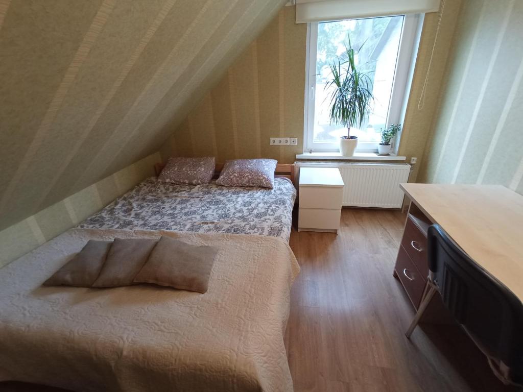 ein kleines Schlafzimmer mit 2 Betten und einem Fenster in der Unterkunft Jurmala's Centre Apartments in Jūrmala