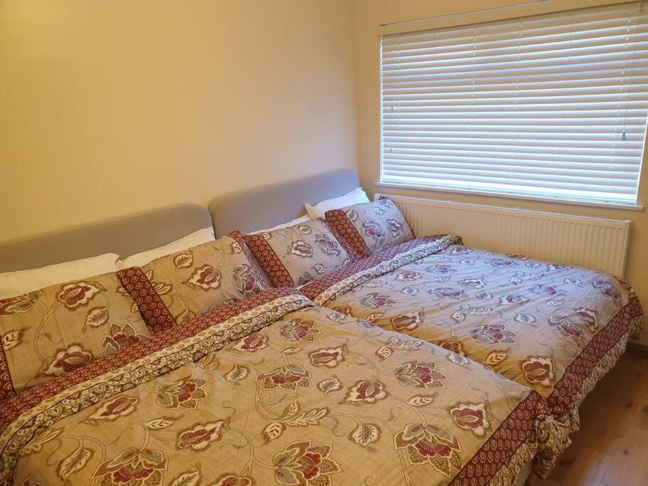 a bed with a comforter and pillows in a bedroom at London Luxury 2 Bedroom Flat Sleeps 8 free parking in East Barnet