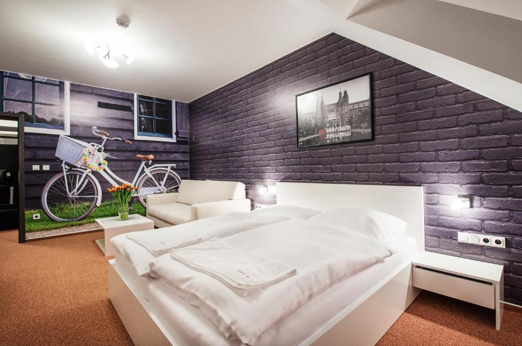 a bedroom with a white bed and a brick wall at Relax21 in Uherský Ostroh