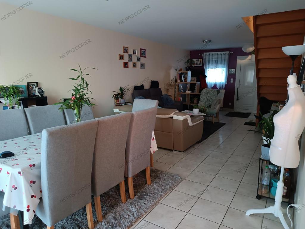 uma sala de estar com mesa e cadeiras em Maison au calme a Arnage em Arnage