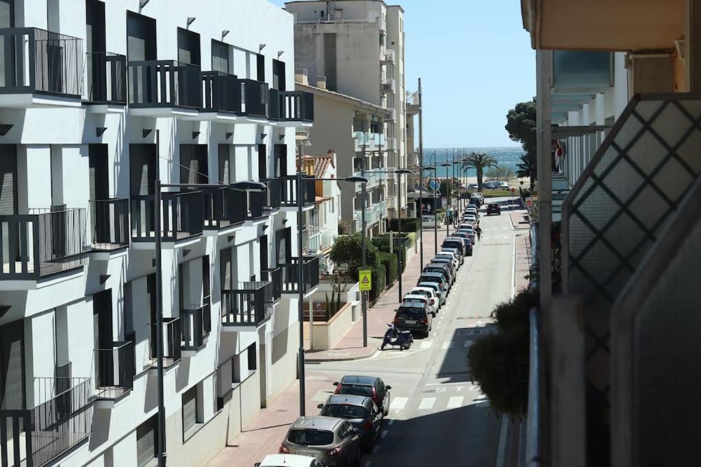 una calle con coches estacionados en el lateral de un edificio en Apartamento a 100 m de la playa! en Torroella de Montgrí