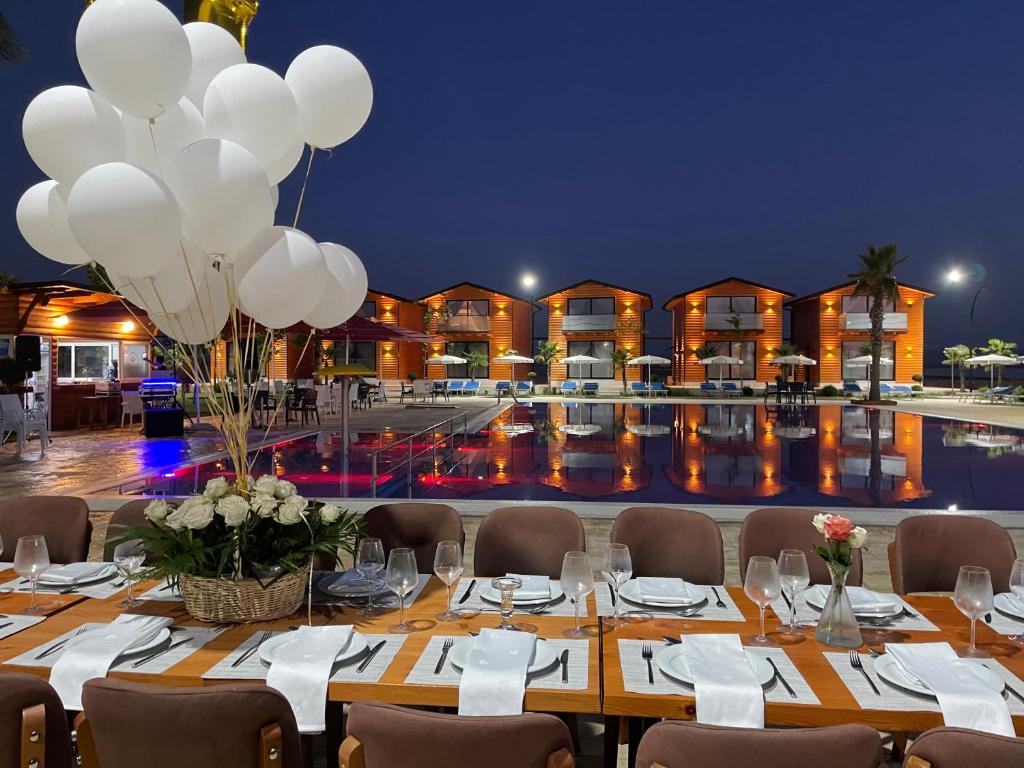 a long table with white balloons and a pool at Kingfish restaurant & boutique hotel in Patog